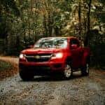 Red Chevy Colorado on a dirt road