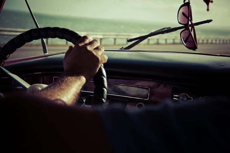 Person holding the steering wheel of a car