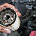 Auto mechanic holding oil filter