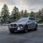 The 2023 BMW X7 driving down a suburban street, one of several great road trip BMW SUVs