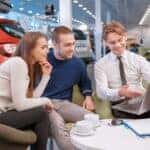 A couple speaking with a BMW financing expert to refinance their car