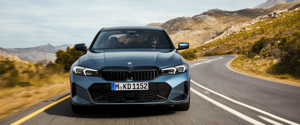 Front view of a 2025 BMW 3 Series being driven on a road
