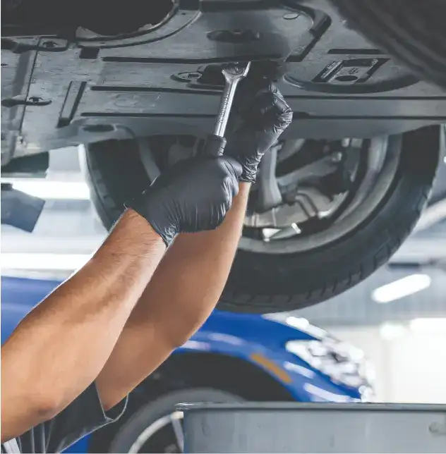 BMW service technician working under a vehicle