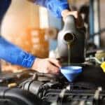 Mechanic changing vehicle's oil to improve BMW fuel efficiency