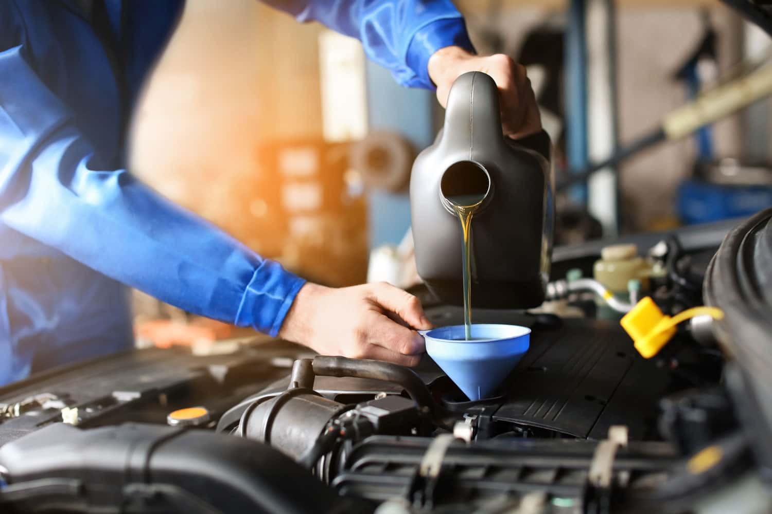 Mechanic changing vehicle's oil to improve BMW fuel efficiency