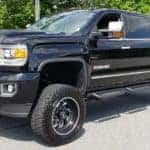 A black GMC Sierra lifted truck from a local dealer