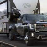 2020 GMC Sierra 3500HD exterior shot towing a massive RV trailer on a country highway