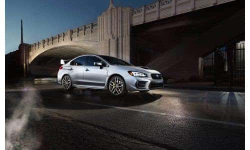 2020 Subaru WRX STI exterior side shot with gray metallic paint color parked by a bridge at night