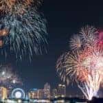 a city skyline at night lit up with lights and exploding fireworks in the sky for a new year's eve celebration