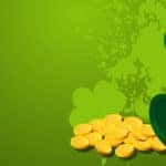 a St. Patrick's Day leprechaun hat with a pile of gold and splashes of green paint shaped like shamrocks behind it