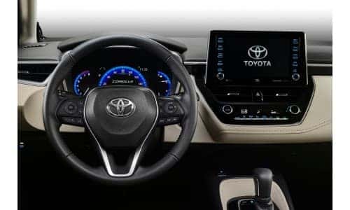 2020 Toyota Corolla interior shot closeup of steering wheel, transmission knob, and infotainment display
