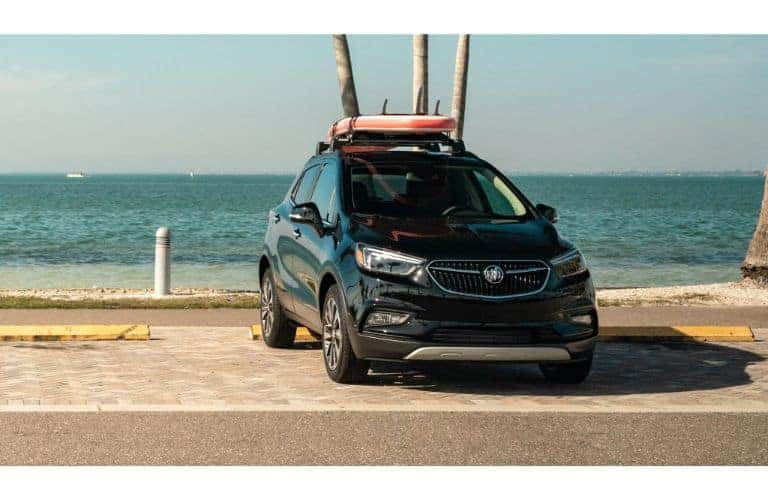 2020 Buick Encore exterior shot with loaded up roof rack parked by a beach and ocean