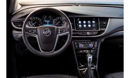 2019 Buick Encore interior shot of driver's seat view of steering wheel, dashboard screens, and transmission