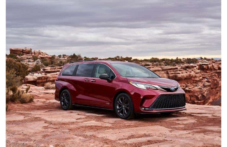 2021 Toyota Sienna XSE exterior shot with dark red paint color parked on a red rock cliff in a desert