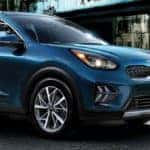 2020 Kia Niro exterior side shot with Deep Cerulean paint color parked in a plaza outside of a hotel lobby