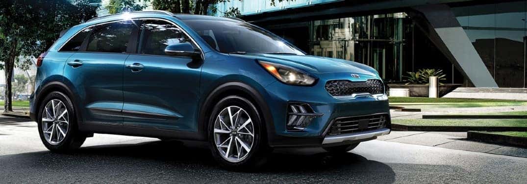 2020 Kia Niro exterior side shot with Deep Cerulean paint color parked in a plaza outside of a hotel lobby