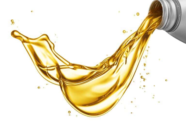 Oil pouring out of a container over a white background