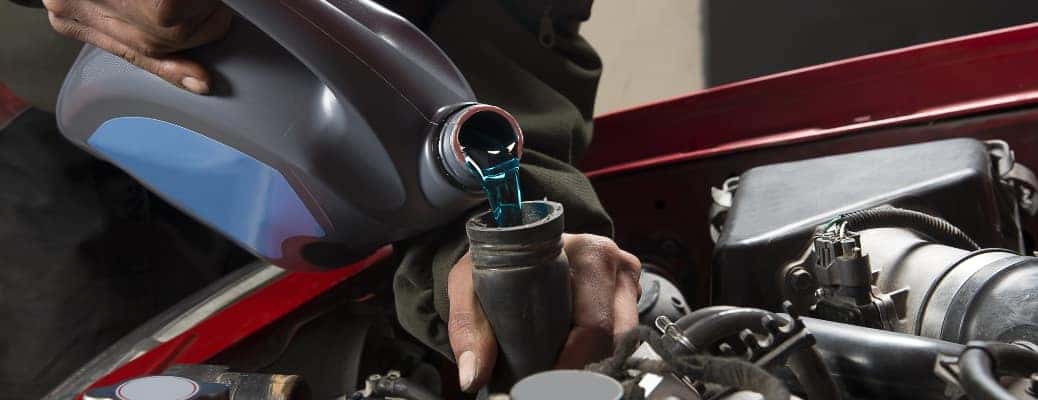 man pouring antifreeze into a cooling system