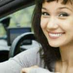 A woman sitting in a car holding a key