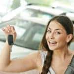 Two people standing in front of a car