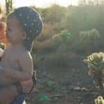 a mom holding a child in a field