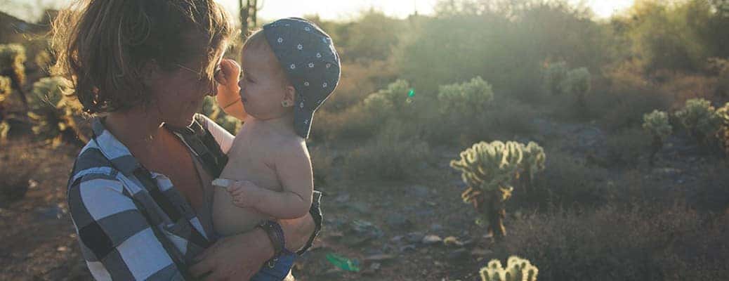 a mom holding a child in a field