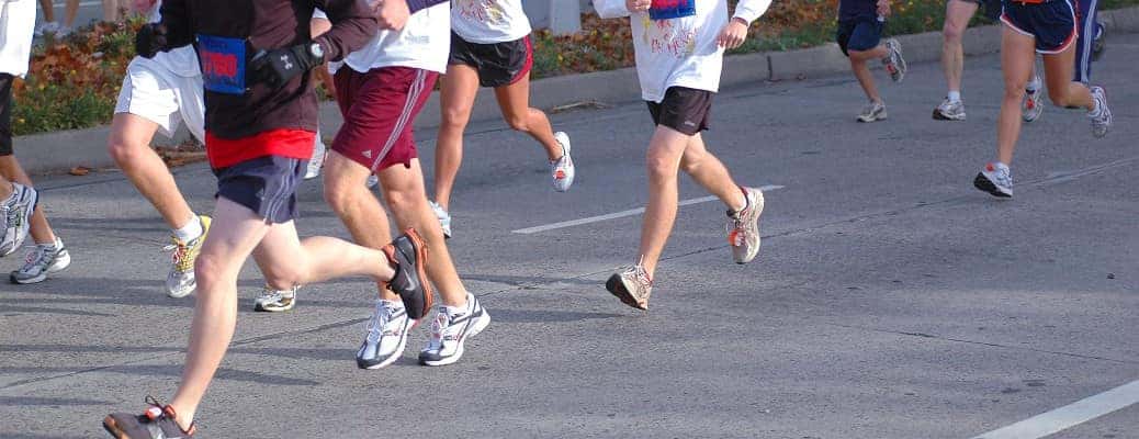 legs and running shoes on a road