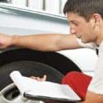 a man inspecting a car tire
