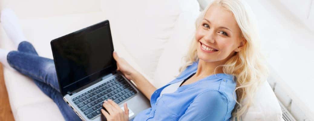 A woman holding a blank laptop