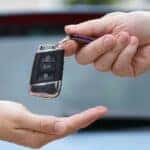 Two hands passing a car key between them