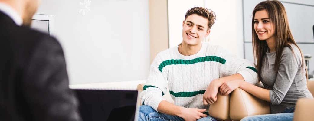 Two young people sitting across from a man