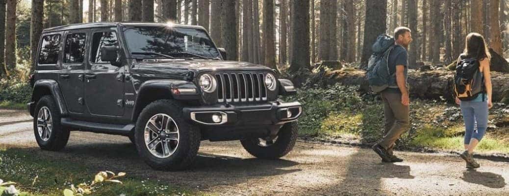 2020 Jeep Wrangler by two people on a forested road