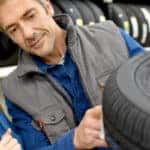 two people looking at a car tire