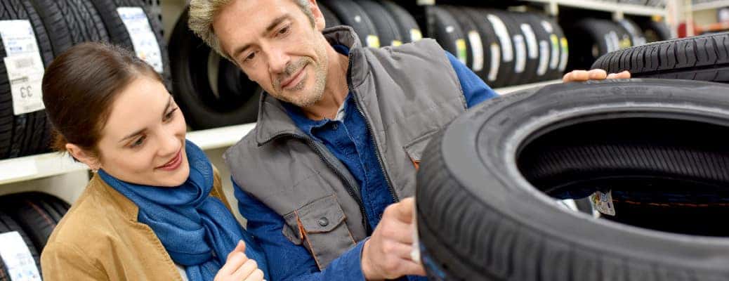 two people looking at a car tire