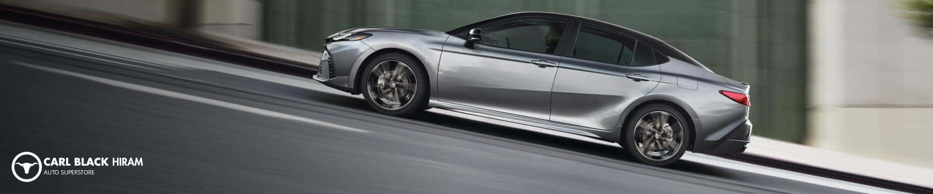 Left profile panning motion shot of a Heavy Metal Toyota Camry XSE descending a steep urban street.