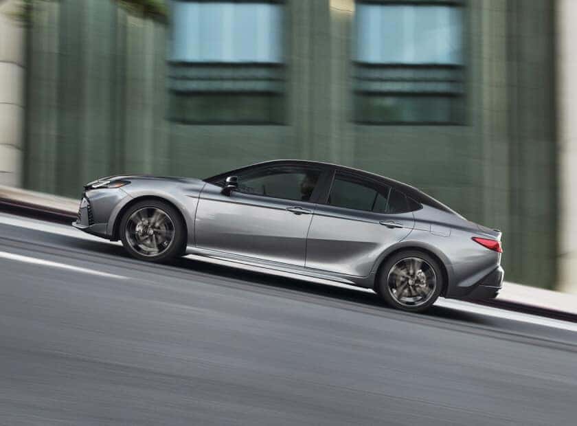 Left profile panning motion shot of a Heavy Metal Toyota Camry XSE descending a steep urban street.