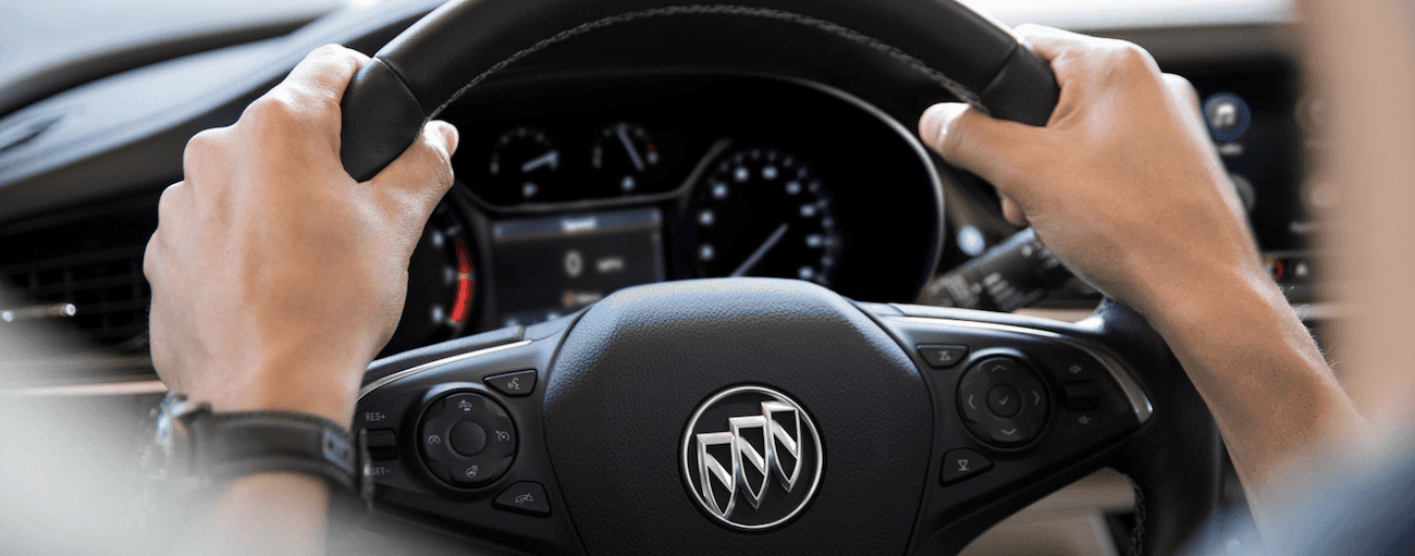 Hands on a black 2019 Buick Regal steering wheel