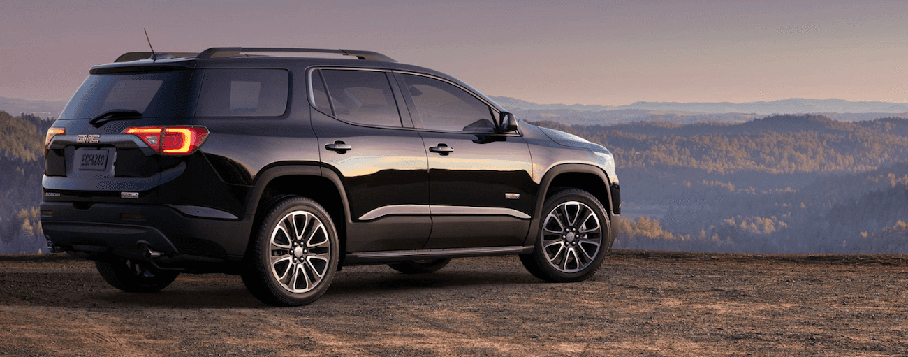 Black 2019 GMC Acadia overlooking valley with trees