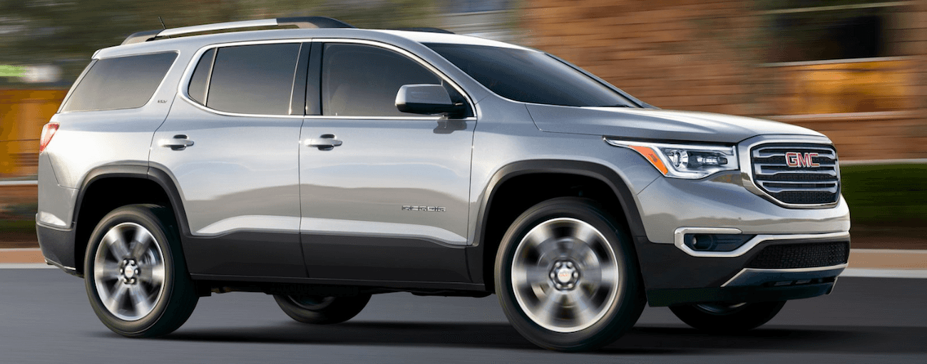 Gray 2019 GMC Acadia driving with out of focus background