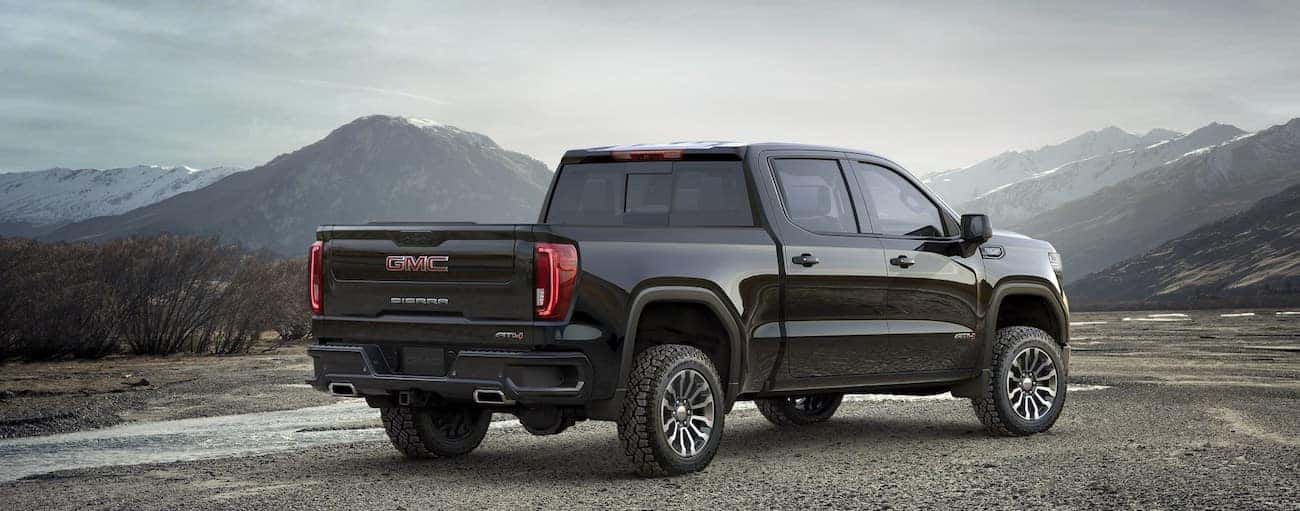 A black 2019 GMC Sierra 1500 sits triumphantly overlooking a mountain pass 