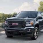 A black 2019 GMC Canyon parked in the driveway of a modern home