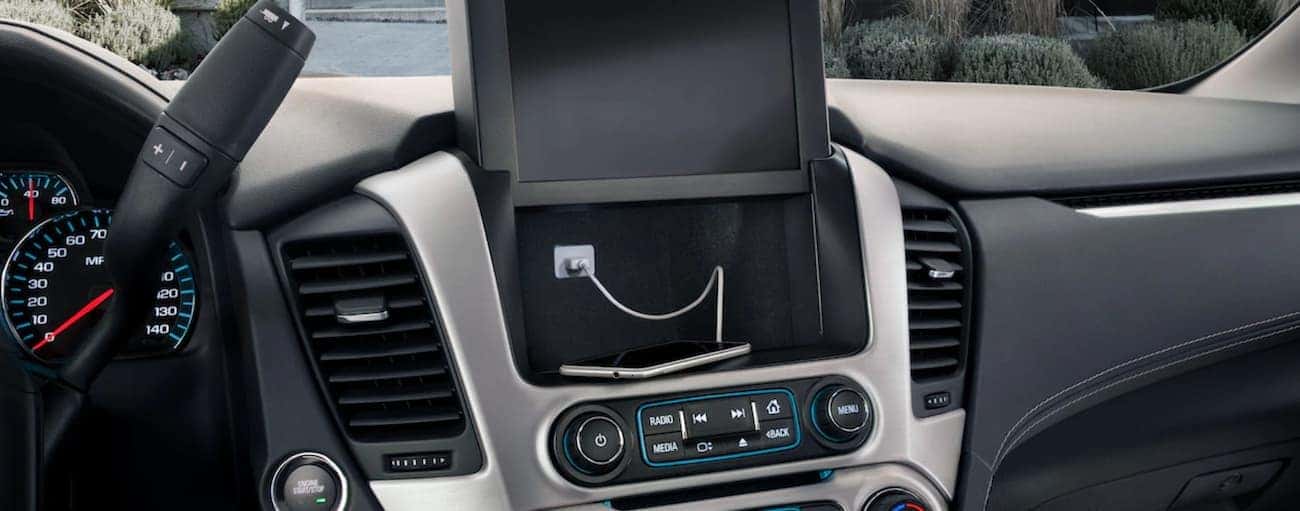 Raised touchscreen showing hidden compartment behind infotainment center in 2019 GMC Yukon