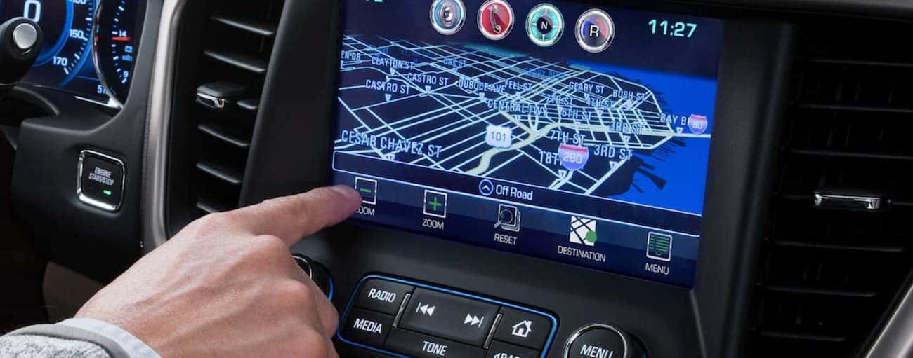 A closeup of a hand pressing buttons on the 2019 GMC Acadia touchscreen