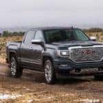 A black 2019 GMC Sierra 2500 Denali driving through mud