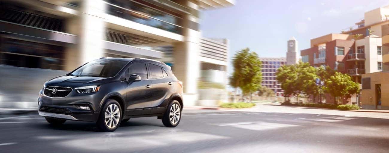 A black 2019 Buick Encore zips down a city side street