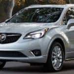 white 2019 Buick Envision driving down tree-lined street