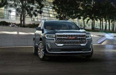 2020 GMC Acadia Denali exterior front fascia and passenger side parked in front of building