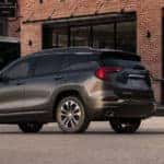 2019-GMC-Terrain-SLT-exterior-back-fascia-and-driver-side-in-front-of-brick-building