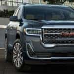 2020 GMC Acadia Denali exterior front fasica and passenger side in front of brick wall