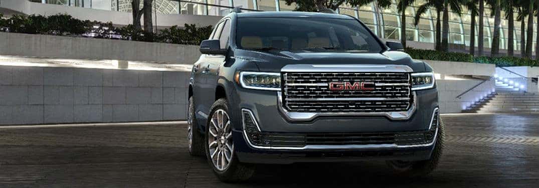 2020 GMC Acadia Denali exterior front fasica and passenger side in front of brick wall